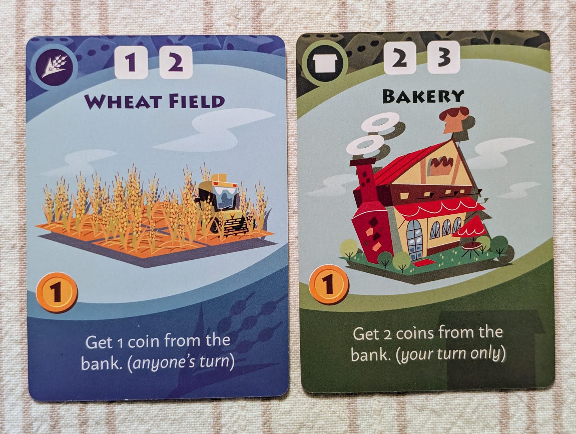 Two cards fomr the game Machi Koro, labeled wheat field and bakery.