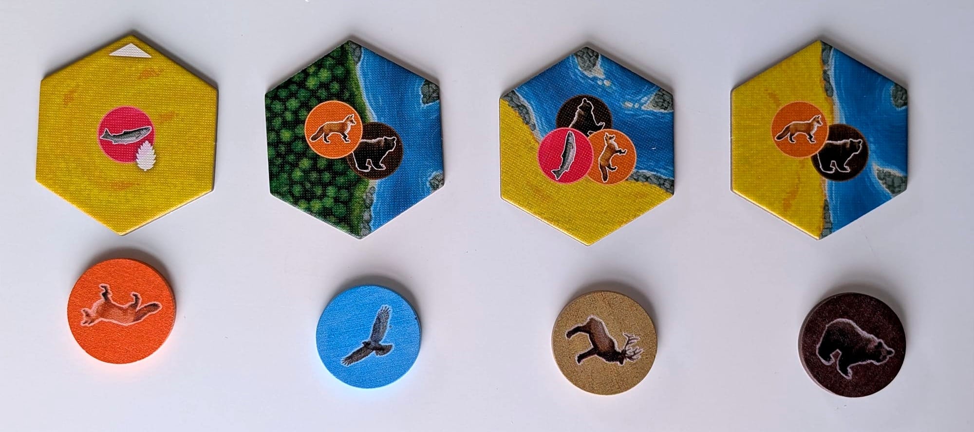 Four pairs of geographical hex tiles, and circular animal tokens.