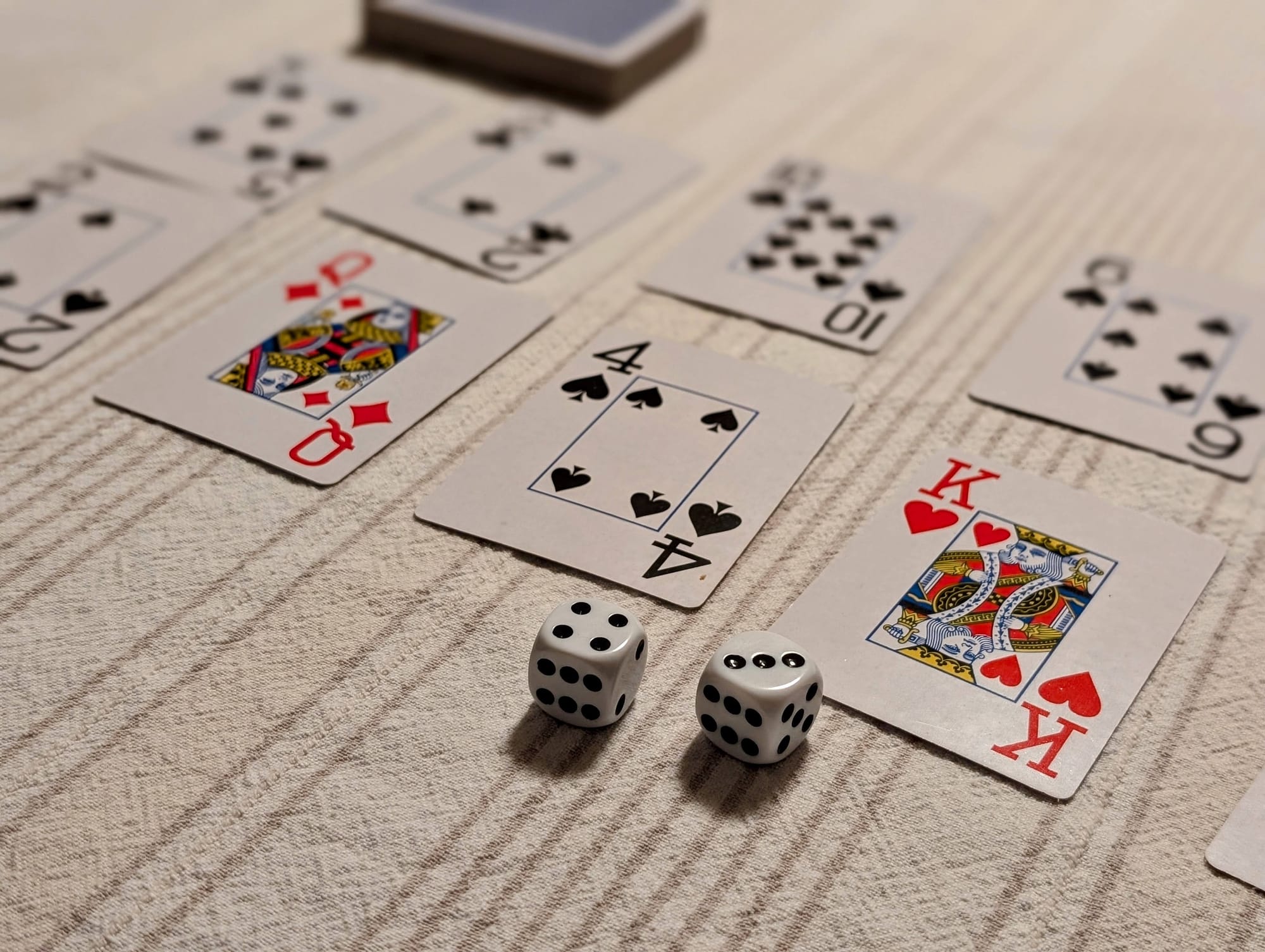 Several playing cards and two dice on a table