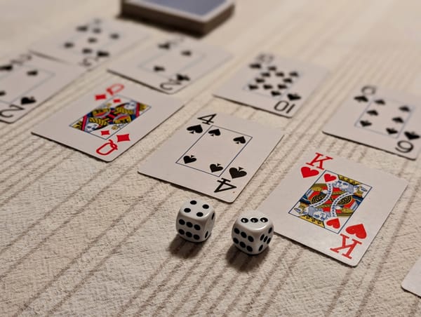 Several playing cards and two dice on a table