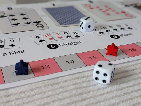 A game board with playing cards, two meeples, and two dice.